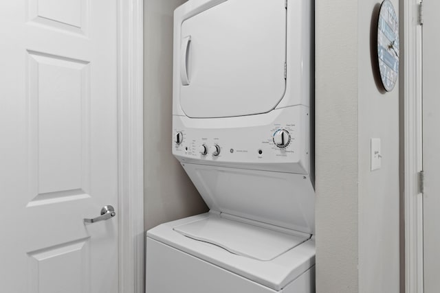 clothes washing area featuring stacked washer / drying machine