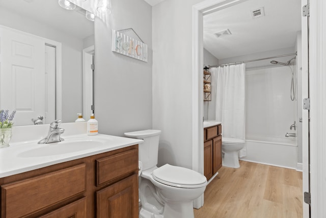 full bathroom with vanity, hardwood / wood-style floors, toilet, and shower / tub combo