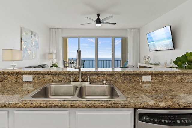 kitchen with stone counters, sink, ceiling fan, and white cabinets