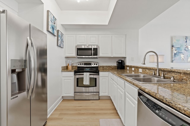 kitchen featuring light hardwood / wood-style flooring, white cabinets, appliances with stainless steel finishes, and sink