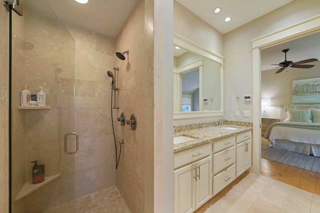 bathroom featuring ceiling fan, vanity, hardwood / wood-style floors, and a shower with door