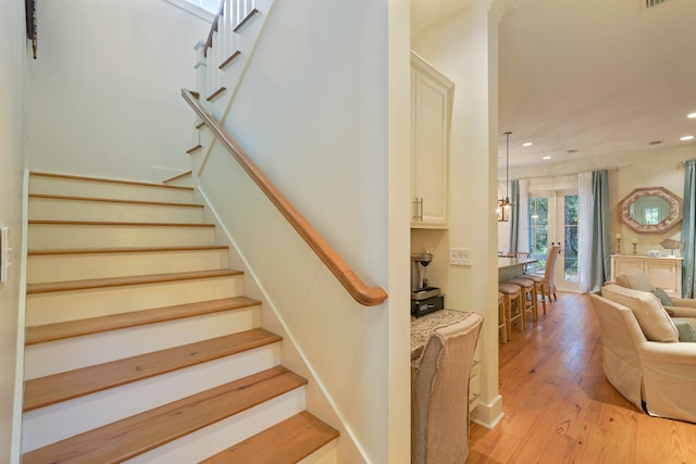 staircase with french doors and hardwood / wood-style flooring