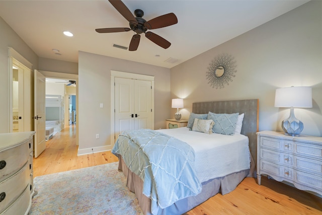 bedroom featuring light hardwood / wood-style floors, ceiling fan, and a closet