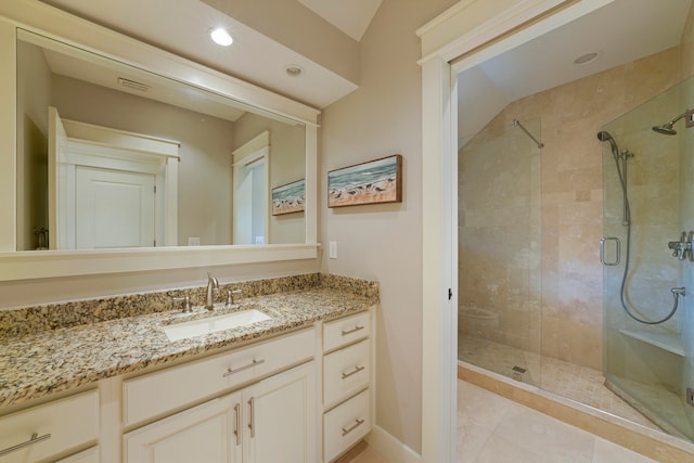 bathroom featuring vanity, tile patterned flooring, vaulted ceiling, and a shower with door