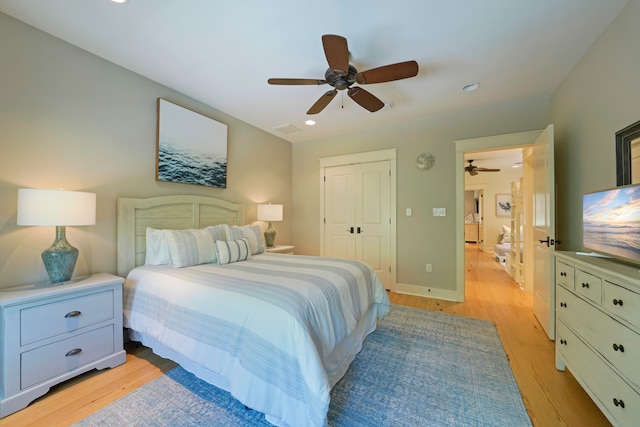 bedroom featuring light hardwood / wood-style floors, ceiling fan, and a closet