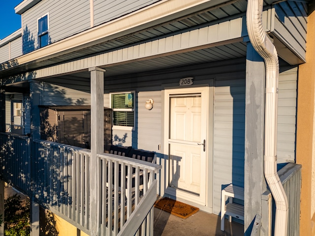 view of exterior entry featuring covered porch