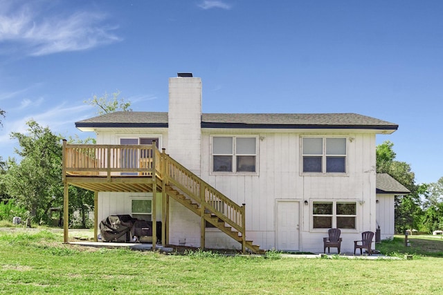 rear view of house featuring a yard and a deck