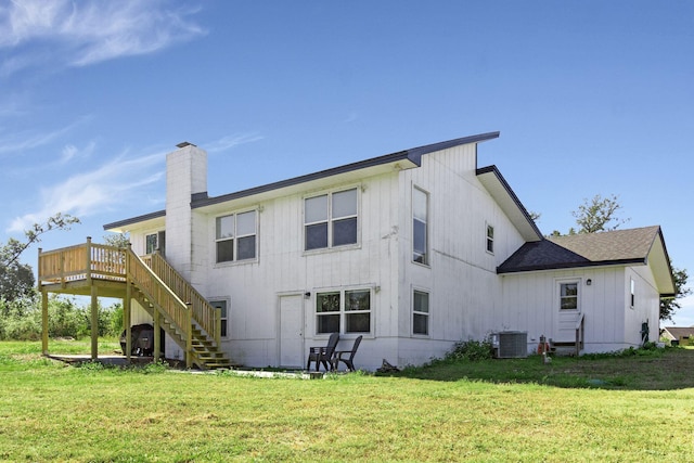 rear view of house featuring cooling unit, a deck, and a yard