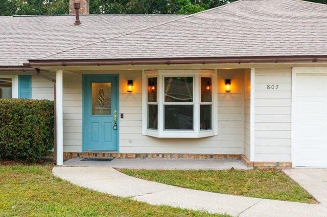 entrance to property featuring covered porch and a garage