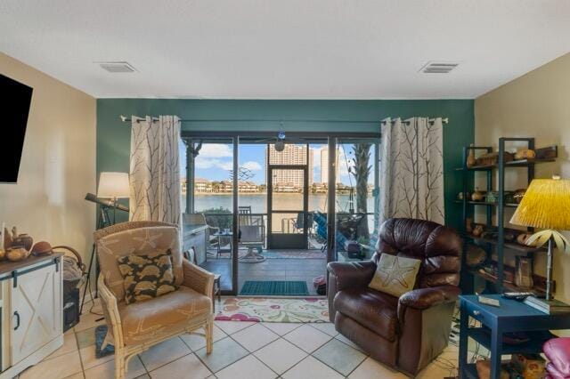 living area with a water view and light tile patterned floors