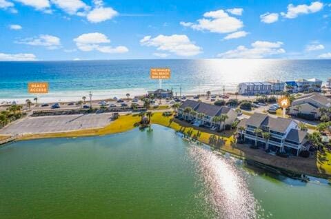 aerial view with a water view and a beach view