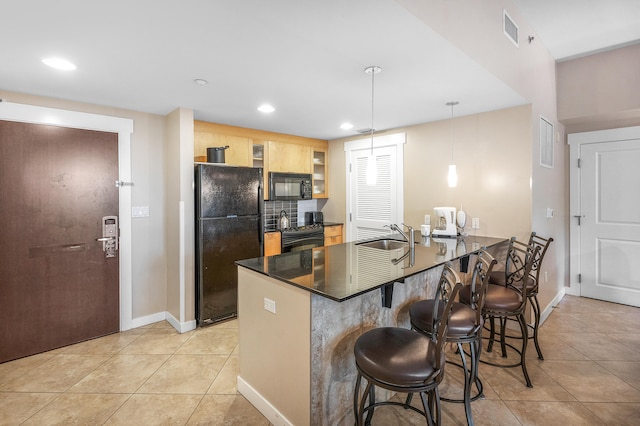 kitchen with decorative light fixtures, kitchen peninsula, black appliances, a kitchen bar, and light tile patterned floors