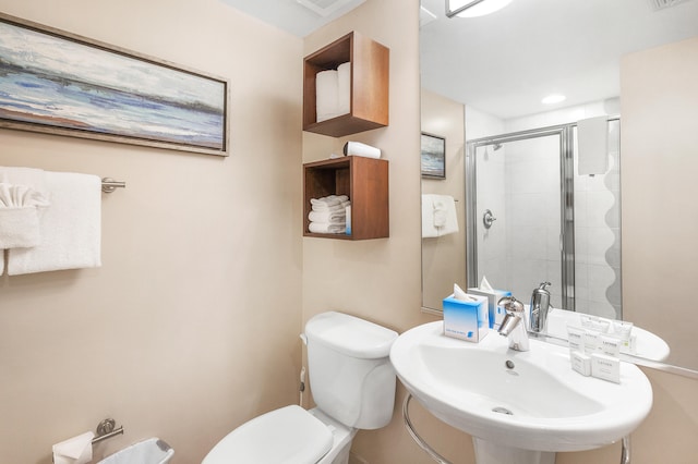 bathroom with an enclosed shower, toilet, and sink