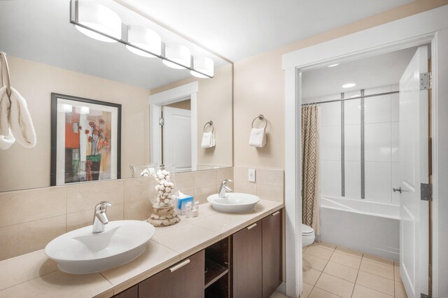 full bathroom with vanity, shower / bath combo with shower curtain, tile patterned flooring, toilet, and backsplash