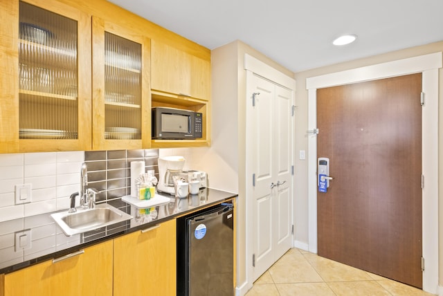 kitchen with light tile patterned flooring, black appliances, decorative backsplash, and sink