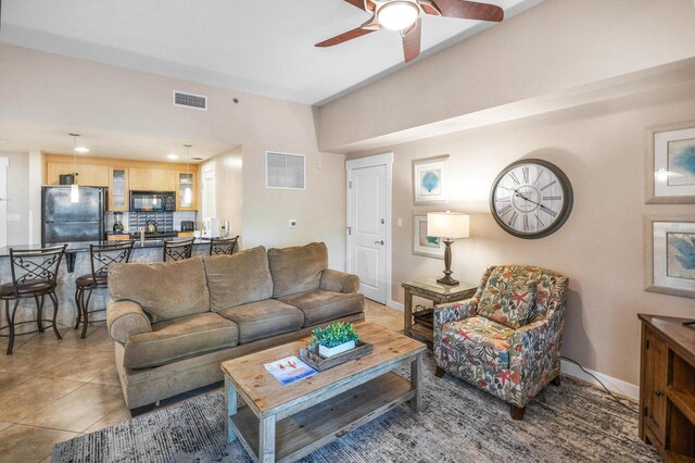 living room featuring ceiling fan and tile patterned flooring