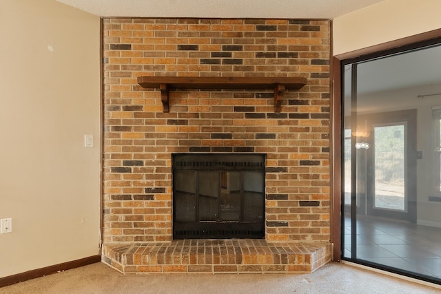 interior details featuring carpet, a textured ceiling, and a brick fireplace