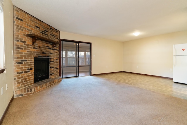 unfurnished living room with light colored carpet and a brick fireplace