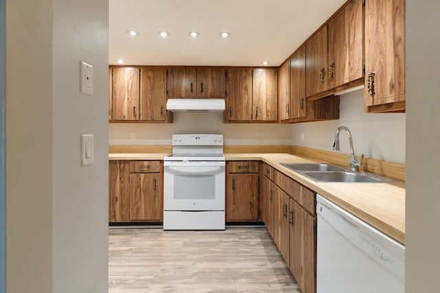 kitchen with sink, white appliances, and light hardwood / wood-style flooring