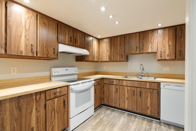 kitchen featuring white appliances, light hardwood / wood-style flooring, and sink