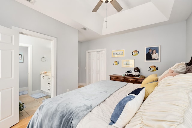 tiled bedroom featuring a closet, ceiling fan, and ensuite bathroom