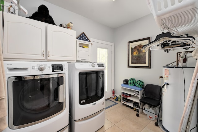 laundry area featuring gas water heater, cabinets, washing machine and dryer, and light tile patterned flooring