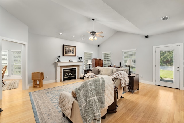 living room featuring ceiling fan, light hardwood / wood-style flooring, lofted ceiling, and a healthy amount of sunlight