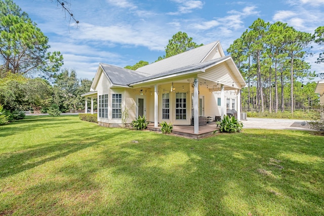 rear view of house featuring a yard, ceiling fan, and a wooden deck