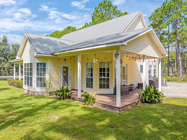 back of house with ceiling fan, a lawn, a patio area, and central AC unit