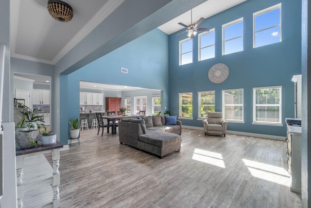 living room featuring ornamental molding, light hardwood / wood-style flooring, and a healthy amount of sunlight