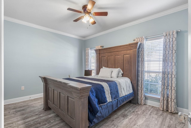 bedroom featuring crown molding, ceiling fan, multiple windows, and hardwood / wood-style flooring