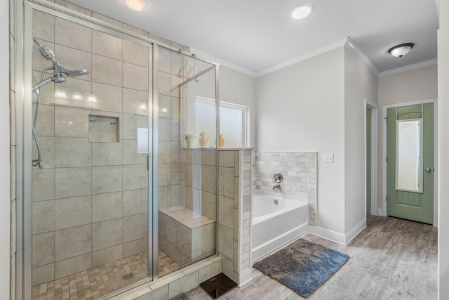 bathroom featuring hardwood / wood-style flooring, ornamental molding, and shower with separate bathtub