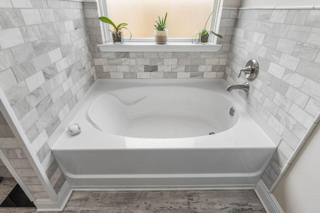 bathroom featuring hardwood / wood-style flooring and a bath