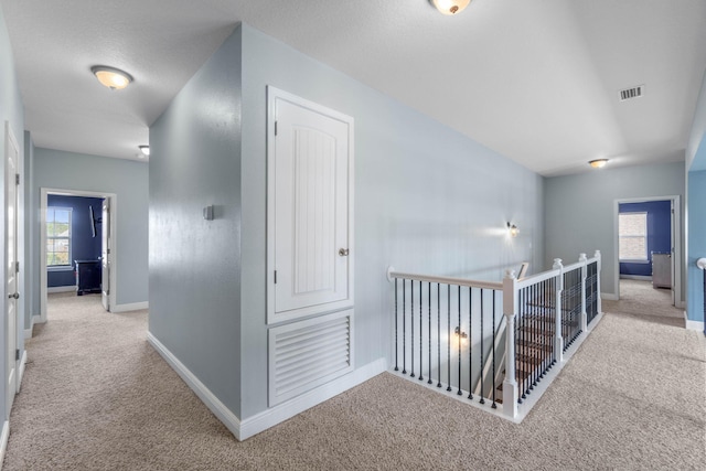 hallway featuring light colored carpet