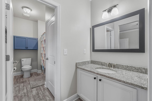 bathroom with a textured ceiling, a shower with shower curtain, hardwood / wood-style floors, toilet, and vanity