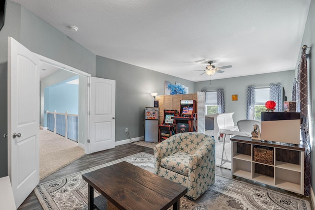 living room featuring a textured ceiling, dark wood-type flooring, and ceiling fan