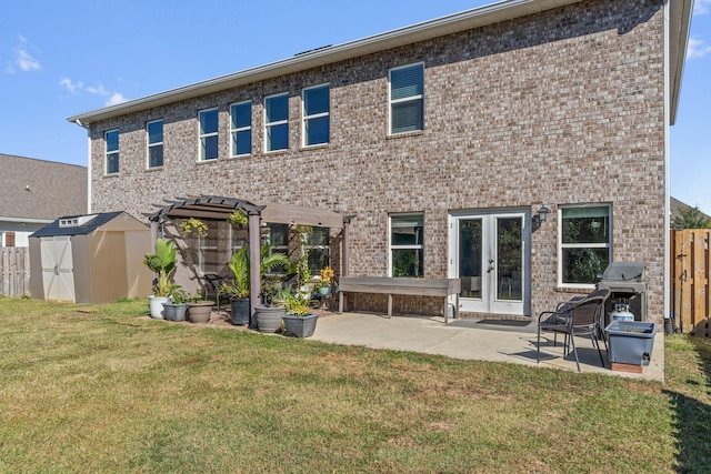 rear view of property with a storage unit, a yard, and a patio area