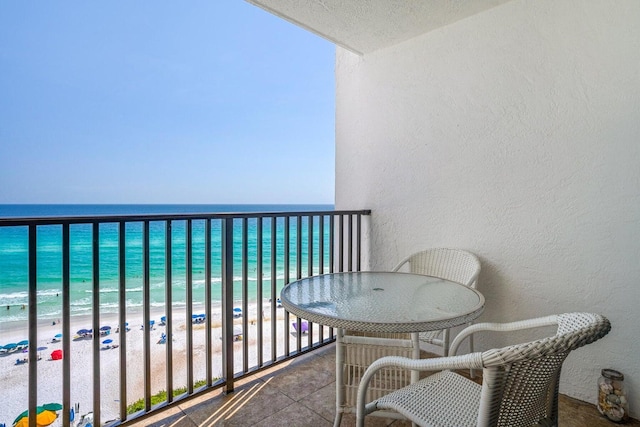 balcony with a water view and a beach view