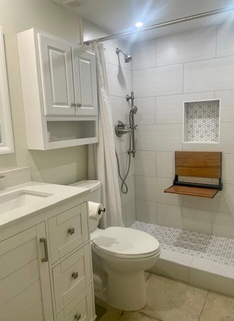 bathroom with tile patterned flooring, vanity, toilet, and curtained shower