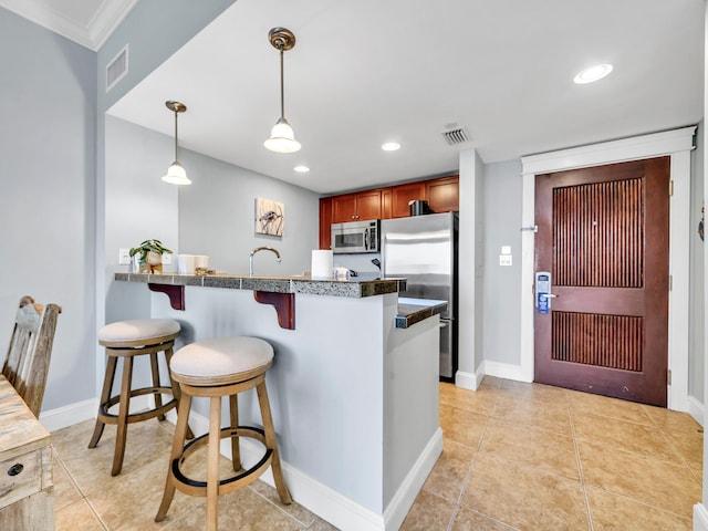 kitchen with a breakfast bar, kitchen peninsula, crown molding, appliances with stainless steel finishes, and decorative light fixtures