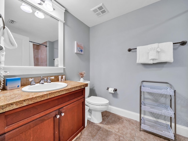 bathroom with tile patterned flooring, walk in shower, vanity, and toilet