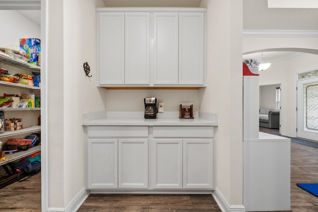 bar with dark wood-type flooring and white cabinetry