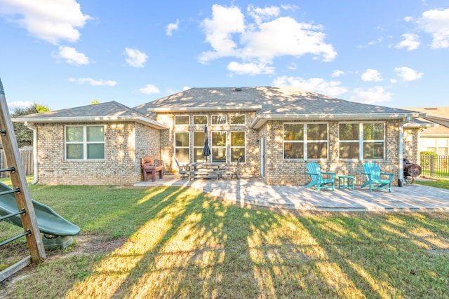 rear view of property featuring a patio area and a lawn