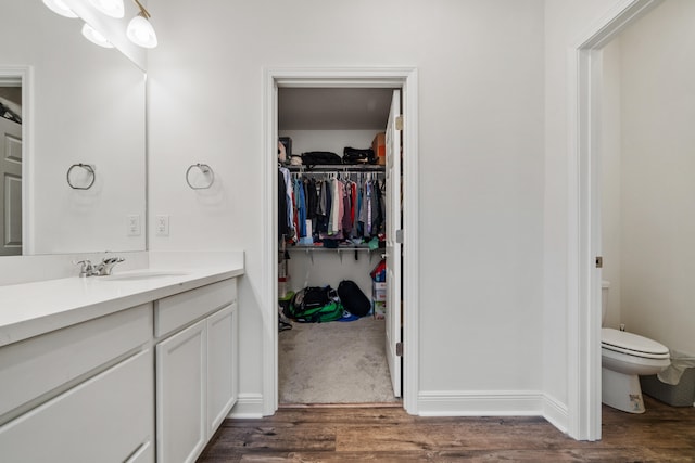 bathroom with hardwood / wood-style floors, vanity, and toilet