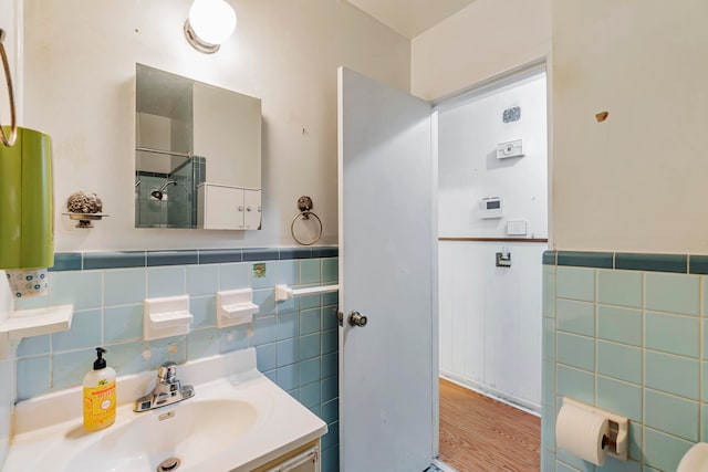 bathroom featuring vanity, tile walls, and hardwood / wood-style floors