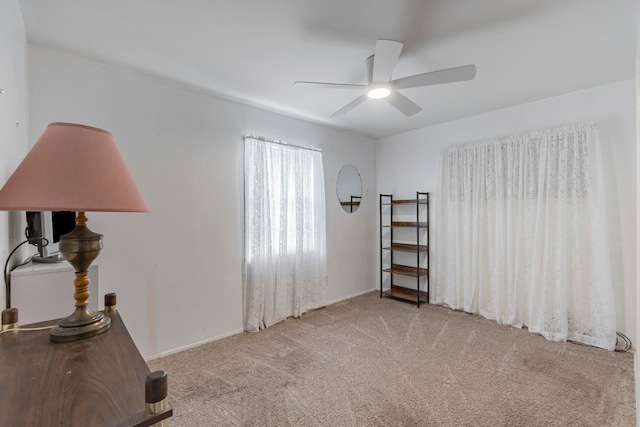 interior space with light carpet and ceiling fan