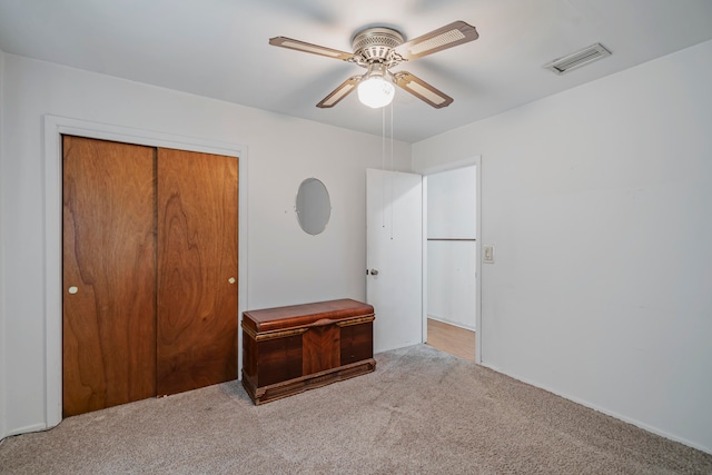 unfurnished bedroom with light carpet, ceiling fan, and a closet