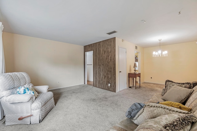 carpeted living room with a chandelier