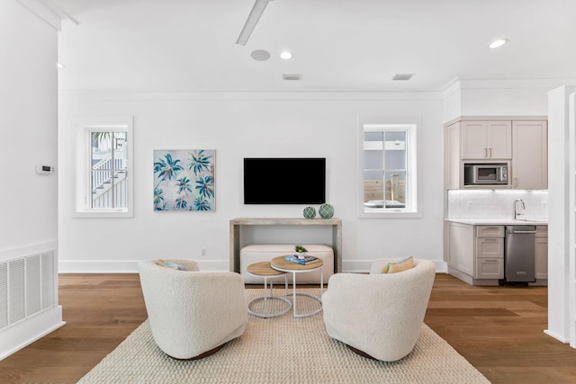 living room with hardwood / wood-style flooring, crown molding, and a wealth of natural light