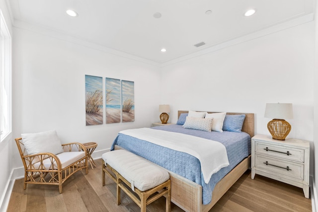 bedroom with hardwood / wood-style flooring and ornamental molding